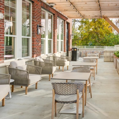 Settle into comfort at Brookwood Point a patio with tables and chairs